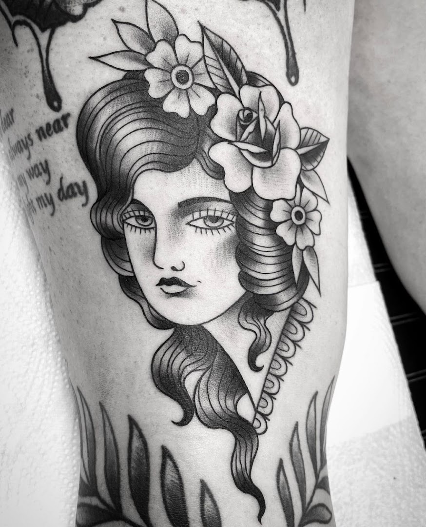 Traditionele tattoo in kleur van een vrouwengezicht met bloemen, gezet bij Inklabel Tattoo