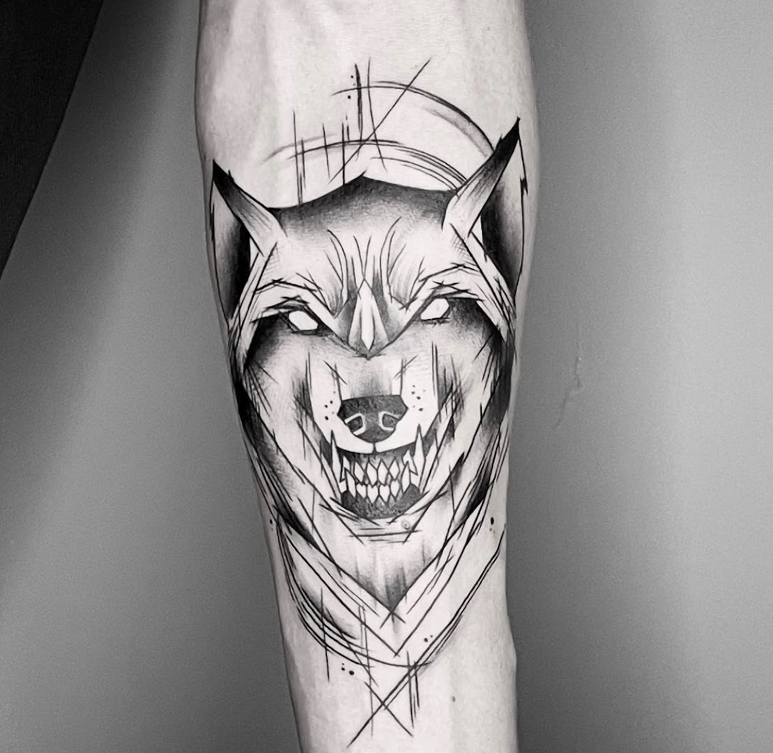 Sketch-style tattoo van een wolvenkop op een onderarm